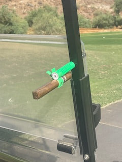 Cigar with a green filter attached to a metal surface outdoors